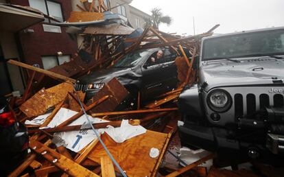 Un cazador de tormentas se sube a su coche para recuperar su equipo tras derrumbarse la fachada de un hotel, durante el paso del huracán Michael por la ciudad de Panamá, en Florida (EE UU), el 10 de octubre de 2018. Michael llegó a Florida considerado un huracán de categoría 4 dentro de una escala de 5, posteriormente, al disminuir la fuerza del viento, cayó a la categoría 3, según avanzaba hacia Alabama y Georgia. Al menos seis personas murieron por este huracán.