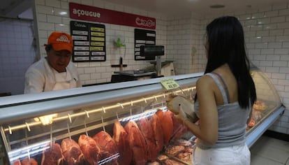 Mulher compra carne no Rio.