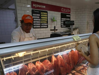 Mulher compra carne no Rio. 