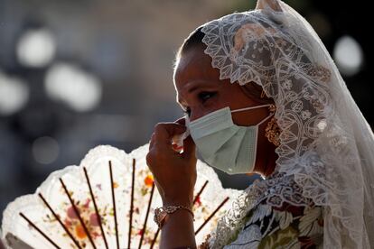 Una fallera se seca las lagrimas durante la Ofrenda a la Virgen, uno de los actos más emotivos de las Fallas, mucho menos multitudinario, sin público, con estrictas medidas sanitarias e indumentarias más ligeras por ser en verano en vez de marzo.