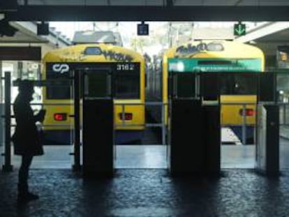 Una mujer aguarda junto a dos trenes fuera de servicio con motivo de otra huelga en Portugal. EFE/Archivo