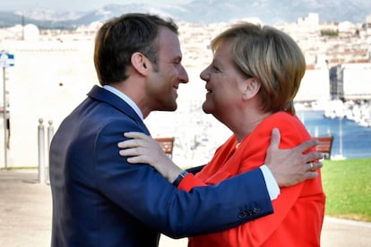 El presidente francés Emmanuel Macron (i) abraza a la canciller alemana, Angela Merkel, este viernes en Marsella