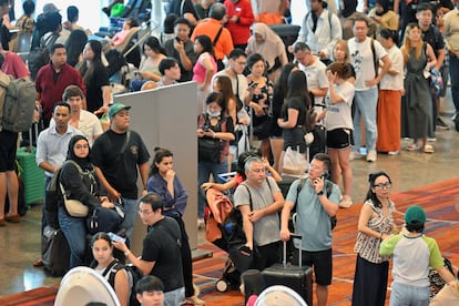 Decenas de pasajeros de la aerolínea Scoot hacen cola para facturar manualmente, este viernes en el aeropuerto de Singapur. 