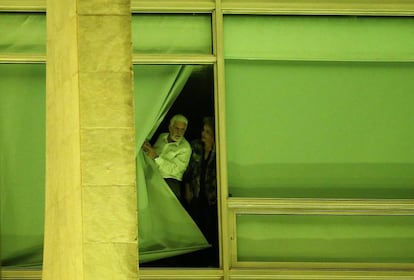 A presidenta Dilma Rousseff e o ministro Jaques Wagner espiam pela janela a movimentação em frente ao Palácio do Planalto, iluminado de verde e amarelo, onde grupos pró e contra o impeachment protestavam na noite desta quarta-feira.