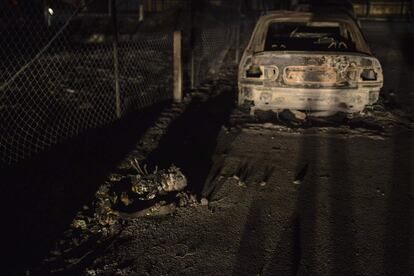 Un cuerpo carbonizado junto a un automóvil calcinado durante los incendios forestales en la aldea de Mati, cerca de Atenas.