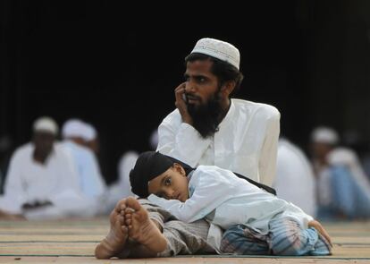 Un niño musulmán duerme en el regazo de su padre antes de tener su Iftar (ruptura del ayuno) durante el mes sagrado del Ramadán en una mezquita de la ciudad india de Chennai. 4 de julio 2014