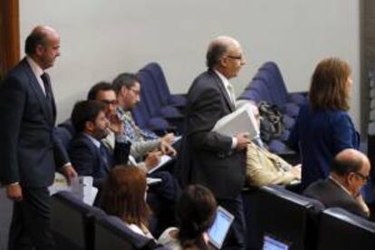 La vicepresidenta del Gobierno, Soraya Sáenz de Santamaría, junto al ministro de Hacienda, Cristóbal Montoro (c), y el
ministro de Economía, Luis de Guindos (i), a la llegada a la rueda de prensa que han ofrecido tras la reunión del Consejo de Ministros, en la que se ha aprobado hoy los presupuestos generales del Estado para 2014, que mantendrán congeladas las retribuciones en el sector público y se apoyarán en un crecimiento económico previsto para el próximo año del 0,7 %.