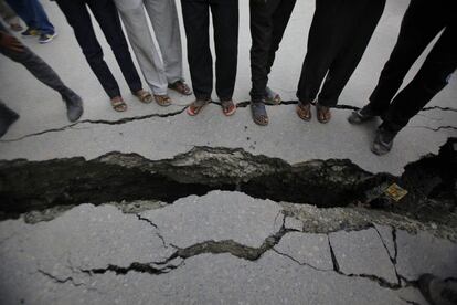 Varias personas, ante una grieta abierta por el terremoto en Katmandú.