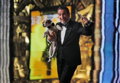 Jean Dujardin, con su Oscar a la mejor interpretación por 'The Artist',y el perro Uggie, en el escenario. La película se ha alzado con 5 premios Oscar.