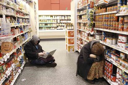 Unas personas descansan en uno de los pasillos del supermercado Publix tras quedar sus vehículos atascados debido a la fuerte tormenta de nieve en Atlanta, Georgia.