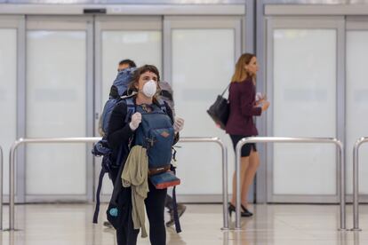 Una mujer protegida con mascarilla en la Terminal 4 del Aeropuerto Adolfo Suárez-Madrid Barajas el 24 de marzo.