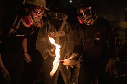 Decenas de miles de personas acabaron marchando, sin que la policía hiciera más gesto de impedirlo que emitir una serie de advertencias públicas a través de comunicados, por las principales avenidas del centro de Hong Kong, pese a la lluvia intermitente. En la imagen, varios manifestantes preparan un cóctel mólotov.