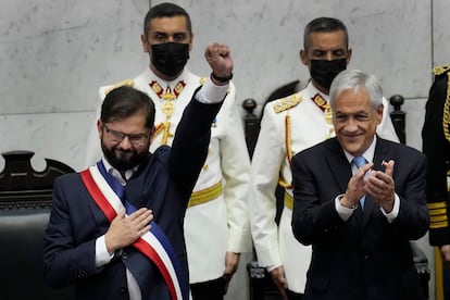 El nuevo presidente de Chile, Gabriel Boric, a la izquierda, levanta el puño mientras el presidente saliente, Sebastián Piñera, aplaude durante la ceremonia de juramentación de Boric en el Congreso en Valparaíso.