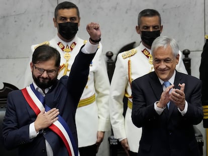 El nuevo presidente de Chile, Gabriel Boric, a la izquierda, levanta el puño mientras el presidente saliente, Sebastián Piñera, aplaude durante la ceremonia de juramentación de Boric en el Congreso en Valparaíso.