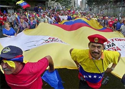 Seguidores de Hugo Chávez portan una bandera de Venezuela en la manifestación en favor del presidente.