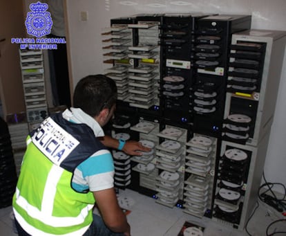 Un agente inspecciona las 19 torres grabadoras incautadas a la red de falsificadores.