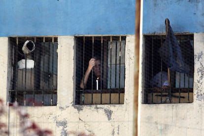 Un preso se asoma por una de las ventanas de la prisión de San Miguel, Santiago de Chile, tras el incendio que ha dejado más de 80 reclusos muertos.