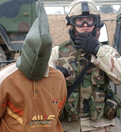 Un iraquí, capturado en Faluya el 1 de enero de 2005, es guiado por un soldado estadounidense, en una imagen proporcionada por el Ejército de EE UU.