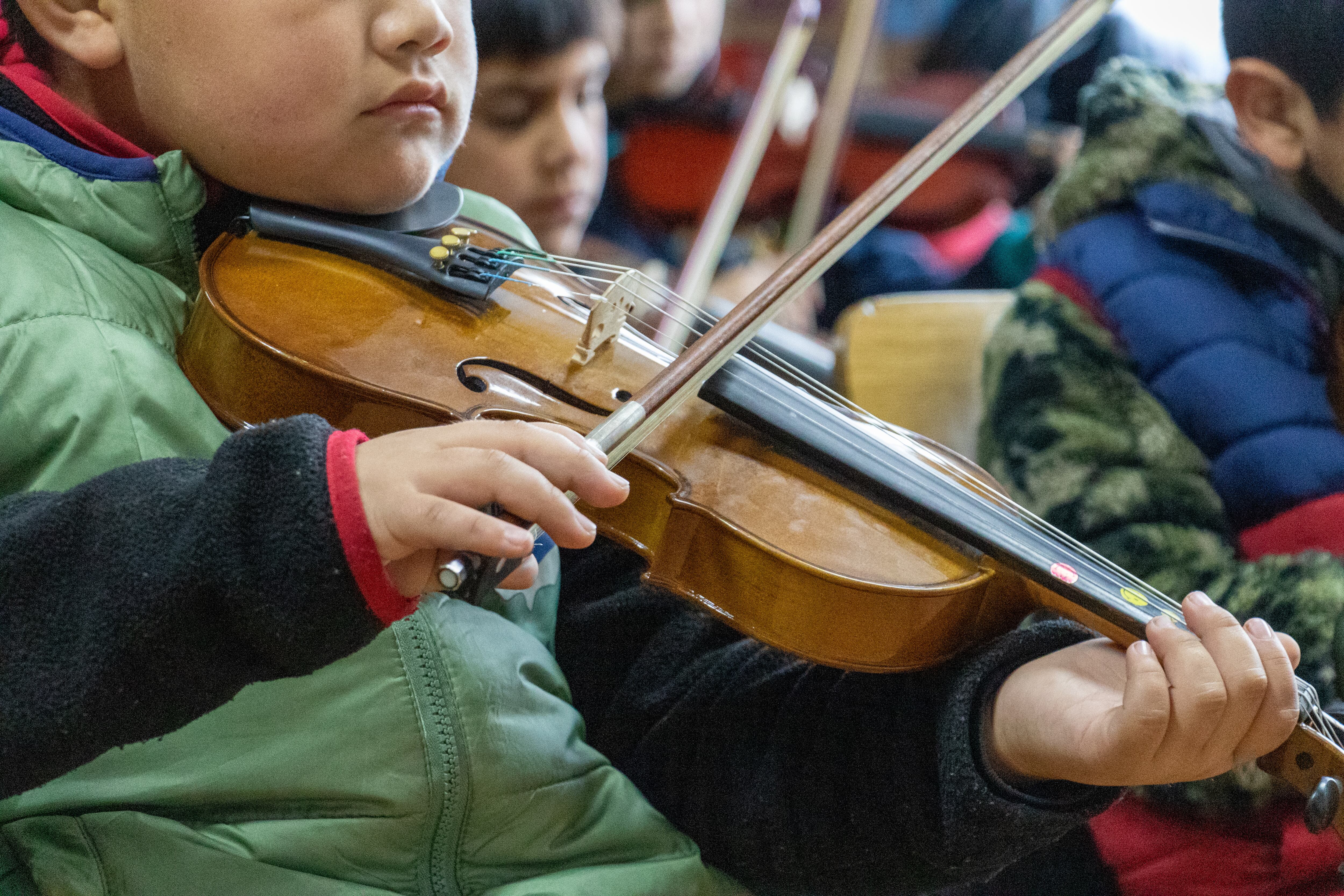 Niños de la orquesta de Fundación Cultural Papageno practican con instrumentos de cuerdas. 