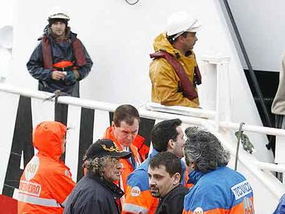 José Manuel Parada (con jersey), uno de los marineros rescatados, a su llegada al puerto de Oza.