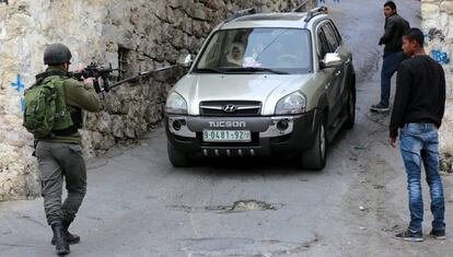 Un soldado israel&iacute; detiene un veh&iacute;culo palestino en Hebr&oacute;n, este martes.