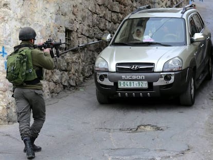 Un soldado israel&iacute; detiene un veh&iacute;culo palestino en Hebr&oacute;n, este martes.