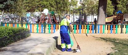 Un barrendero limpia en el parque del Casino de la Reina.