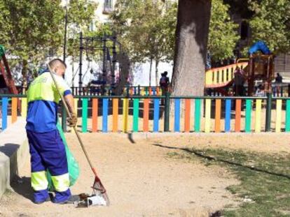 Un barrendero limpia en el parque del Casino de la Reina.