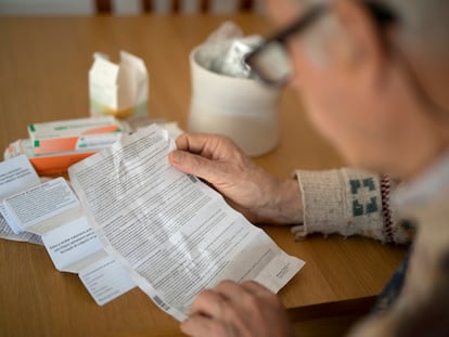 Un paciente lee los prospectos de sus medicamentos en su domicilio.
