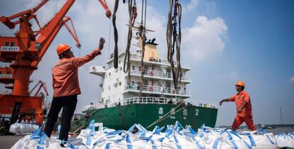 Trabajadores descargan productos químicos en el puerto chino de Zhangjiagang.