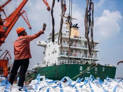 Trabajadores descargan productos químicos en el puerto chino de Zhangjiagang.
 