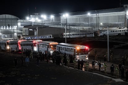 Guardias del Centro de Reclusión del Terrorismo trasladan a presuntos miembros del Tren de Aragua, este domingo en San Luis Talpa, El Salvador. 