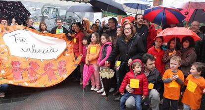 Algunos de los participantes en el pasacalles del Pare Catal&agrave; esperan que escampe a la puerta del colegio.