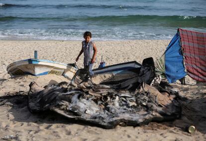 Una niña palestina mira unos barcos destruidos por fuego israelí, en el sur de la Franja de Gaza, el 22 de mayo.