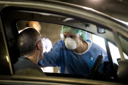 Una enfermera aplica un test rápido a un hombre que acude en su coche, con cita previa, a este área del hospital de campaña instalado en un aparcamiento del HUCA. Los sanitarios y personal que trabajan en áreas sensibles de contagio tienen preferencia.