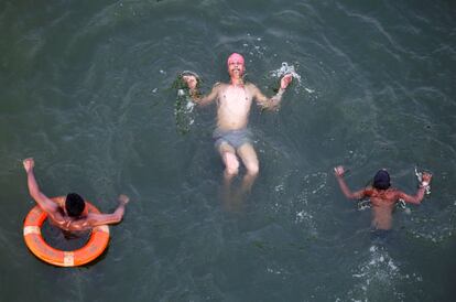 Gente nada para refrescarse de un día de calor en el río Yamuna, en Allahabad, India.