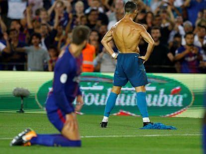 Who's the daddy? Piqué looks on at a shirtless Cristiano Ronaldo.