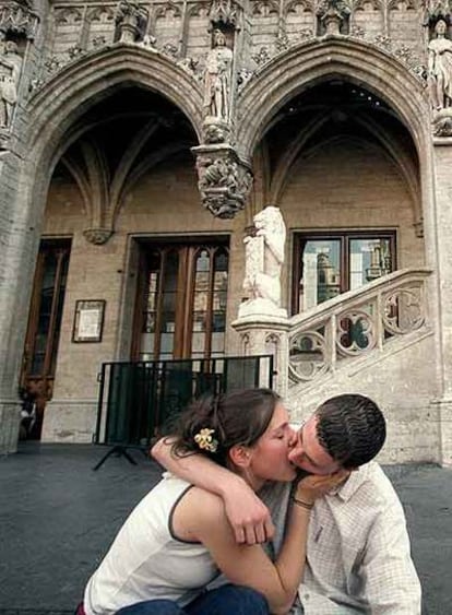 Una pareja se besa en la Grand Place de Bruselas.