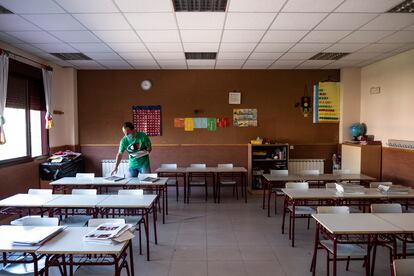 Un profesor prepara un aula para el inicio del curso en el colegio Fuente del Palomar de Alcorcón (Madrid).