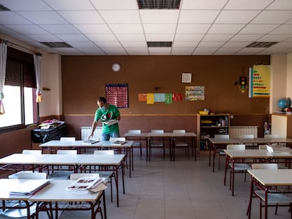 Un profesor prepara un aula para el inicio del curso en el colegio Fuente del Palomar de Alcorcón (Madrid).