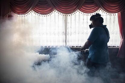 Un trabajador fulmiga una escuela para exterminar mosquitos en un esfuerzo por controlar la propagación del virus Zika, en Bangkok (Tailandia).