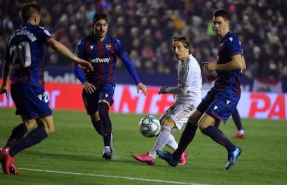 El mediocentro del Real Madrid Luka Modric (C) pasa el balón entre los jugadores de la UD Levante Jorge Miramon, Jose Campana y Nikola Vukcevic, durante el encuentro disputado en el estadio Ciutat de Valencia entre la UD Levante y el Real Madrid CF.