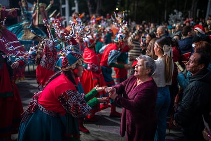 Una mujer baila con una de las artistas de la comparsa navideña. El parque contará con diferentes actividades culturales hasta el 26 de diciembre.