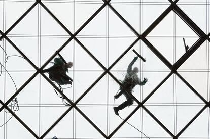 Dos limpiadores de ventanas trabajan a 27 metros de altura en un edificio de la ciudad alemana de Dresde.