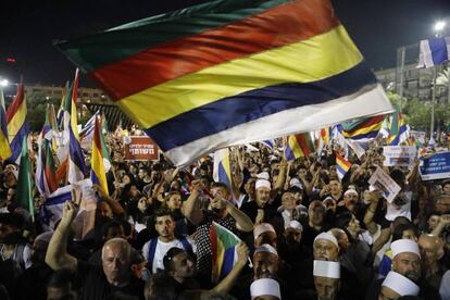 Manifestantes contra la ley del Estado nación ondean la bandera drusa en Tel Aviv.