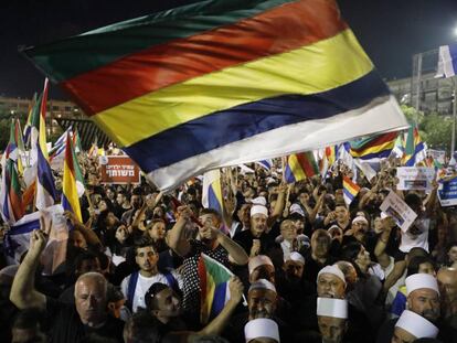 Manifestantes contra la ley del Estado nación ondean la bandera drusa en Tel Aviv.