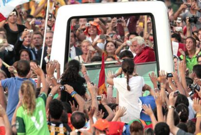 La multitud aclama y fotografía a Benedicto XVI en su <i>papamóvil</b> por la plaza de Cibeles, ayer.