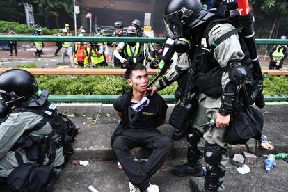 A polícia prende um manifestante ferido na Universidade Politécnica de Hong Kong.