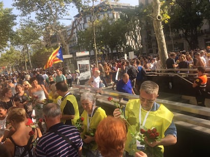 Desenes de voluntaris reparteixen roses grogues i vermelles amb cartells de "No a la islamofòbia".