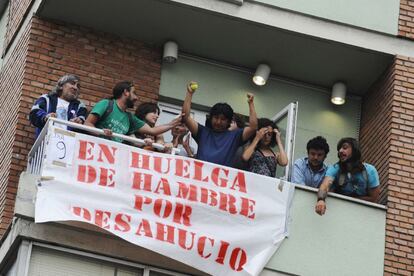 El propietario de la vivienda, Jorge Cordero (centro) protesta contra el desahucio junto a miembros de Stop Desahucios.